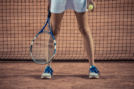 Closeup portrait of female legs with tennis racket and ballの写真素材