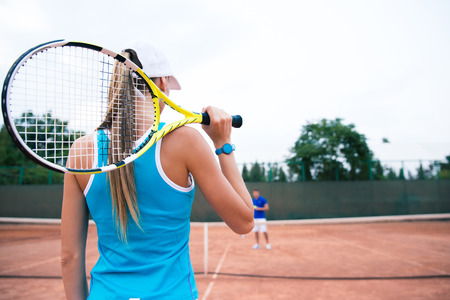 Back view portrait of a woman playing in tennis outdoorsの写真素材