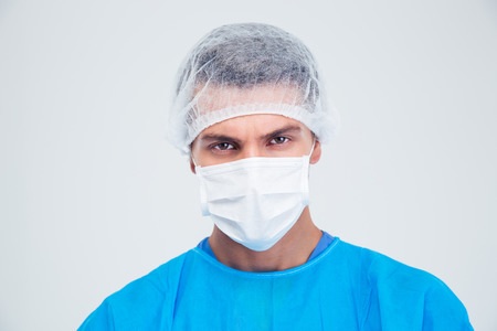 Portrait of a serious surgeon looking at camera isolated on a white backgroundの写真素材