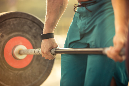 Closeup portrait of a man workout with barbell