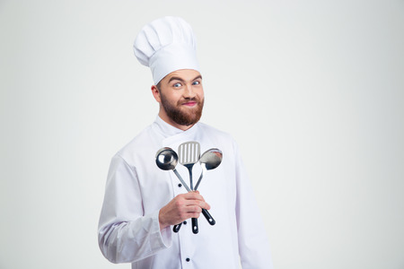 Portrait of a funny male chef cook holding spoons isolated on a white backgroundの写真素材