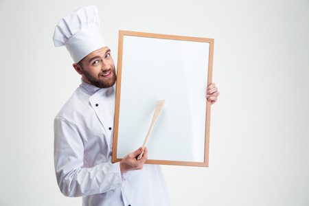 Portrait of a happy male chef cook holding blank board isolated on a white backgroundの写真素材