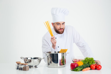 Portrait of a male chef cook preparing pasta isolated on a whtie backgroundの写真素材