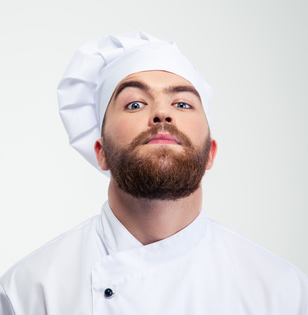 Portrait of a serious male chef cook looking at camera isolated on a white backgroundの写真素材