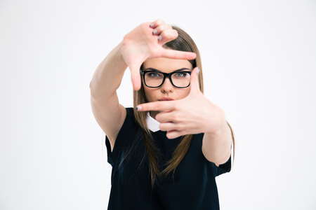 Portrait of a young woman making frame with fingers isolated on a white backgroundの写真素材