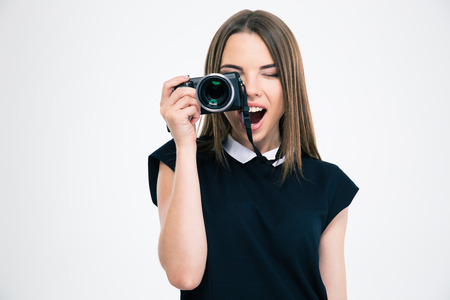Portrait of a cheerful woman making photo on camera isolated on a white background