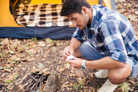 Portrait of a young man kindle bonfire in the forestの写真素材