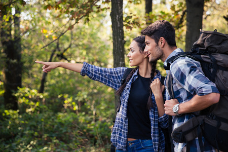 Portrait of a woman pointing on something to her boyfriend in forestの写真素材