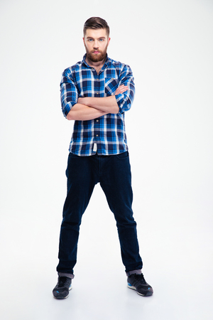 Full length portrait of a confident casual man standing with arms folded isolated on a white backgroundの写真素材