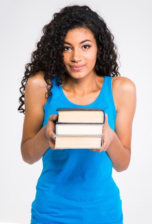 Portrait of a beautiful afro american woman holding books isolated on a white backgroundの写真素材