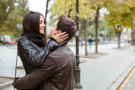 Portrait of a smiling woman embracing with her boyfriend outdoorsの写真素材