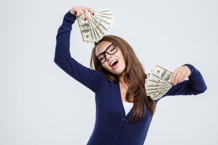 Portrait of a happy beautiful woman with closed eyes holding money isolated on a white backgroundの写真素材