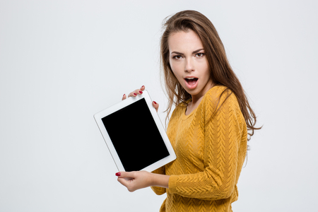 Portrait of a happy woman showing blank tablet computer screen isolated on a white backgroundの写真素材