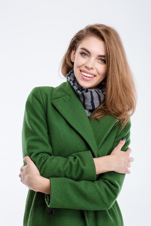 Portrait of a smiling fashion woman in coat looking at camera isolated on a white backgroundの写真素材