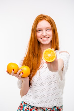 Portrait of pretty young woman holding juicy delicious orangeの写真素材