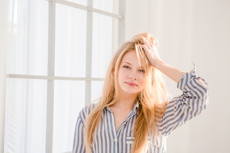 Portrait of relaxed pretty young woman with tousled hair in striped pajamasの写真素材