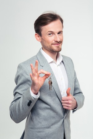 Portrait of a happy businessman showing ok sign and thumb up isolated on a white backgroundの写真素材