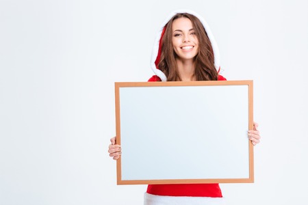 Portrait of a smiling woman in santa claus cloth holding blank board isolated on a white backgroundの写真素材