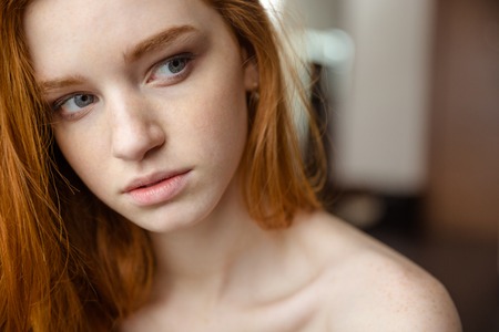 Beauty portrait of sensual thoughtful young woman with red hair looking awayの写真素材