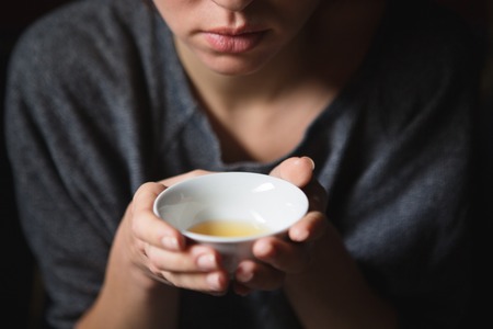Closeup portrait of a young woman smelling teaの写真素材
