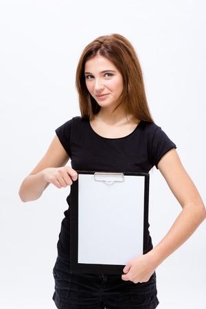 Beautiful confident young woman holding blank clipboard over white backgroundの写真素材