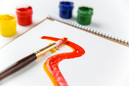 Art album pages, paintbrushes and colorful paints over white backgroundの写真素材