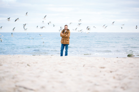 Portrait of a happy man standing with arms folded at the beachの写真素材