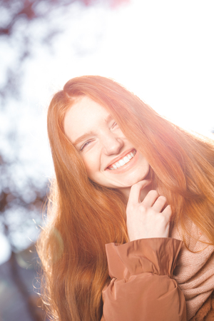 Portrait of a funny redhead woman looking at camera outdoorsの写真素材