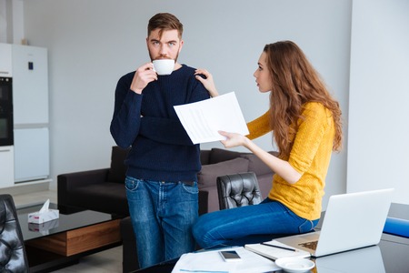 Portrait of a young couple discussing about domestic bills at home