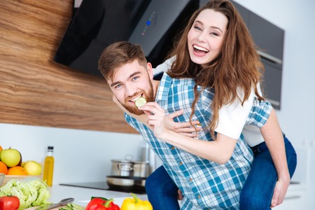 Funny happy couple laughing and having fun on the kitchenの写真素材