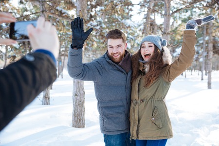 Happy couple photographing in winter park