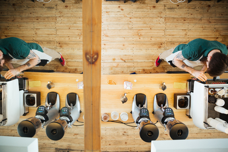 Top view portrait of barista preparing coffee in coffee shopの写真素材