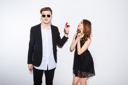 Portrait of a young man making proposal with ring to his girlfriend isolated on a white backgroundの写真素材