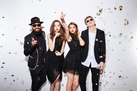 Group of attractive young friends standing ans gesturing over white backgroundの写真素材