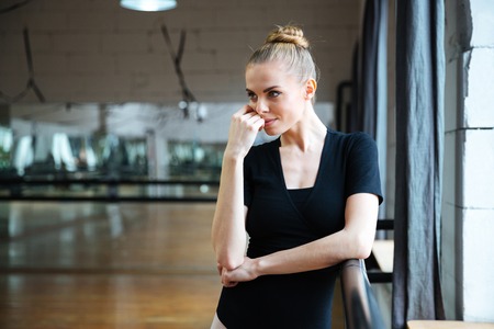 Relaxed woman standing in ballet class and looking awayの写真素材