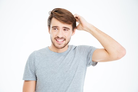 Happy thoughtful man standing over white backgroundの写真素材