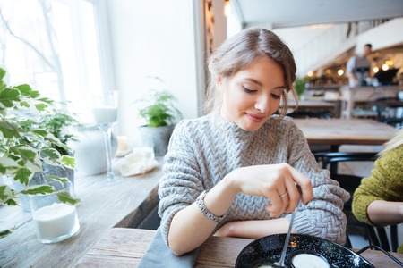 Beautiful woman eating in restaurantの写真素材