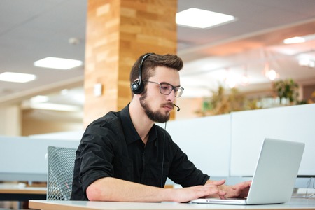 Businessman working on laptop computer in call centerの写真素材