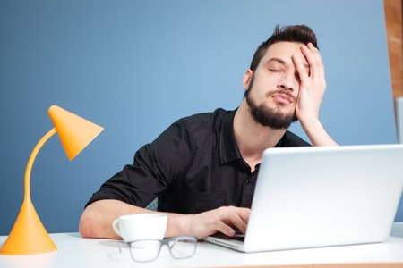 Tired businessman sleeping on the table in officeの写真素材