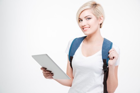 Female student holding tablet computer and looking at camera isolated on a white backgroundの写真素材