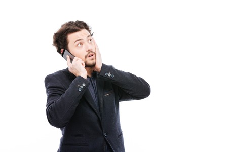 Thoughtful businessman talking on the phone isolated on a white backgroundの写真素材