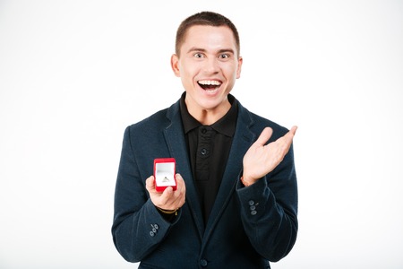 Cheerful businessman holding engagement ring isolated on a white backgroundの写真素材