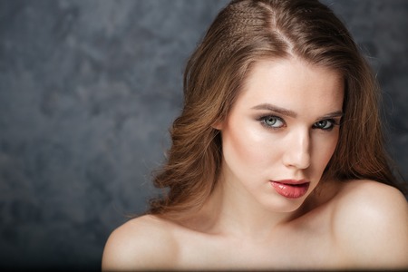 Beauty portrait of sensual attractive young woman over grey backgroundの写真素材