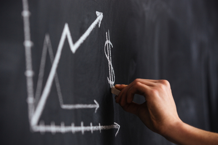 Increasing graph of currency rate drawn by hand on blackboard with chalkの写真素材