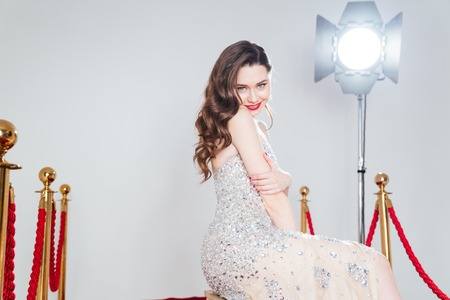 Smiling pretty woman in fashion dress looking at amera