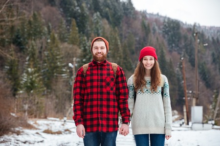 Smiling young couple traveling in winter forestの写真素材
