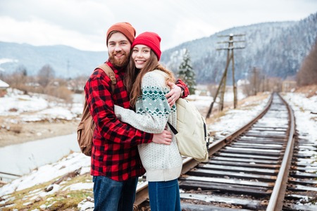 Portrait of beautiful couple standing and hugging on railwayの写真素材