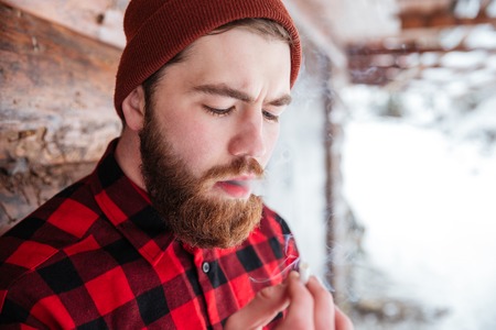 Hipster man smoking cigarette outdoorsの写真素材