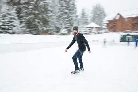 Man ice skating outdoors with snow on background