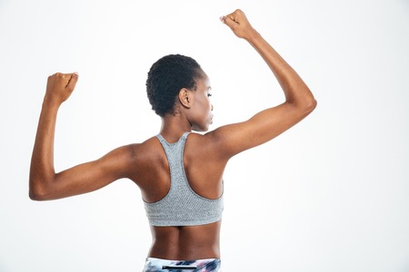 Back view portrait of afro american woman showing her biceps isolated on a backgroundの写真素材